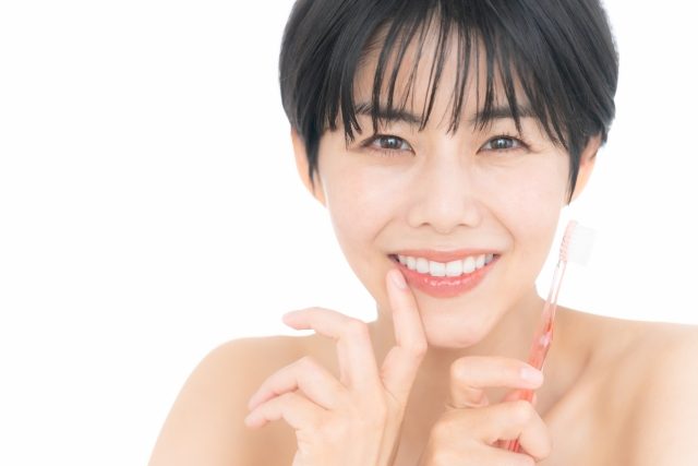 歯ブラシを持つ笑顔の女性